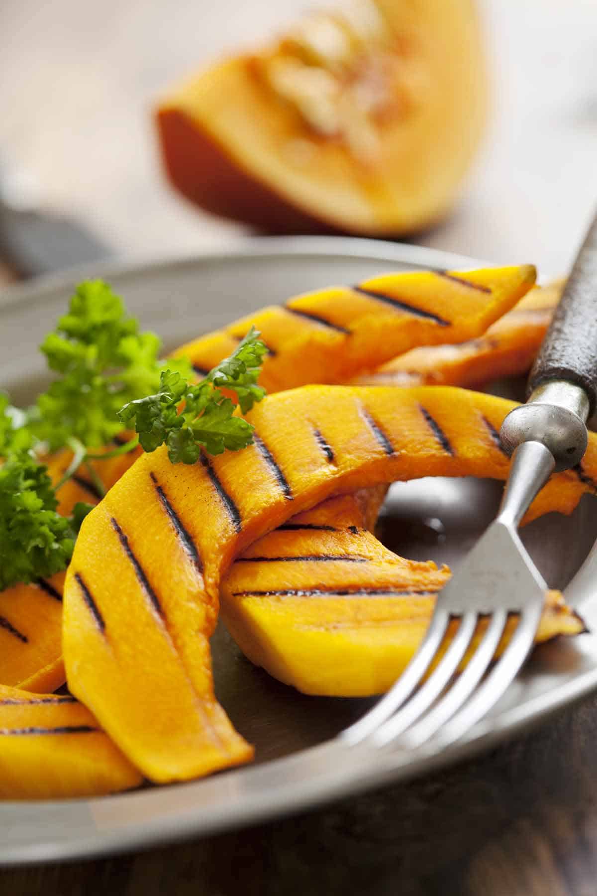 Grilled pumpkin slices on a plate.