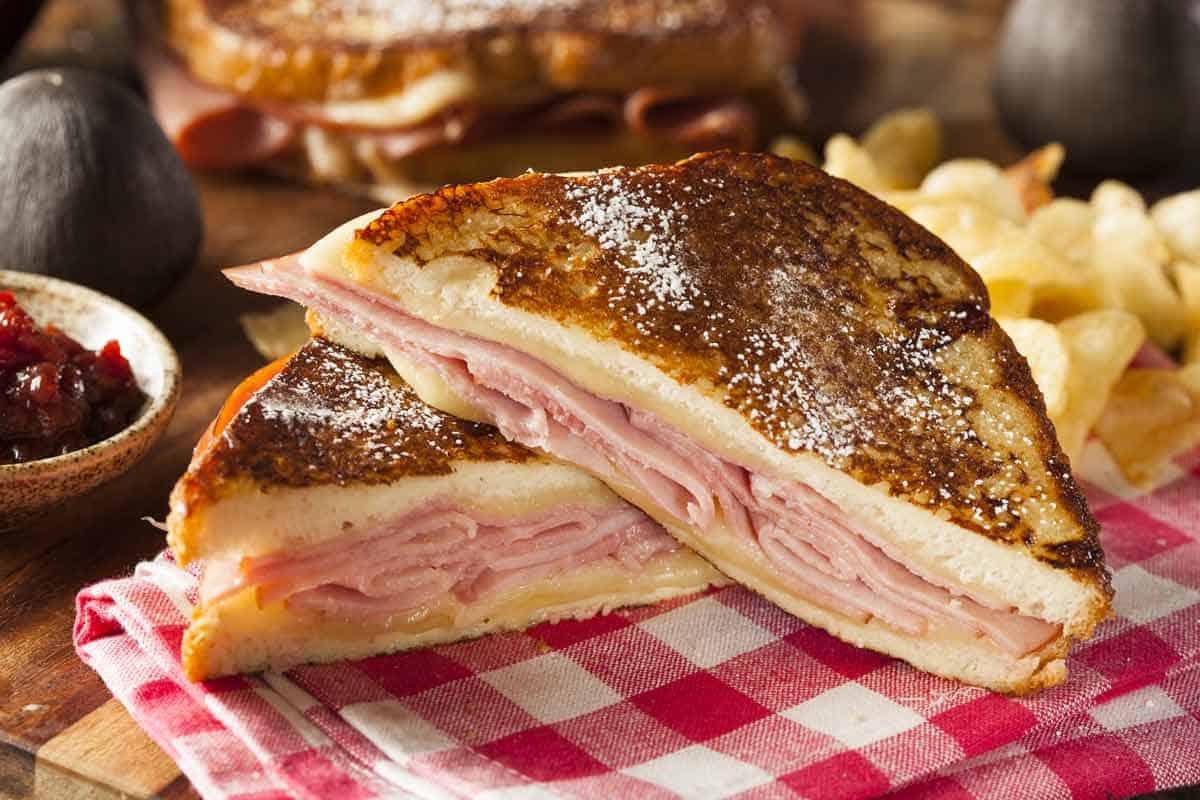 Monte cristo sandwich cut in half with chips in the background.
