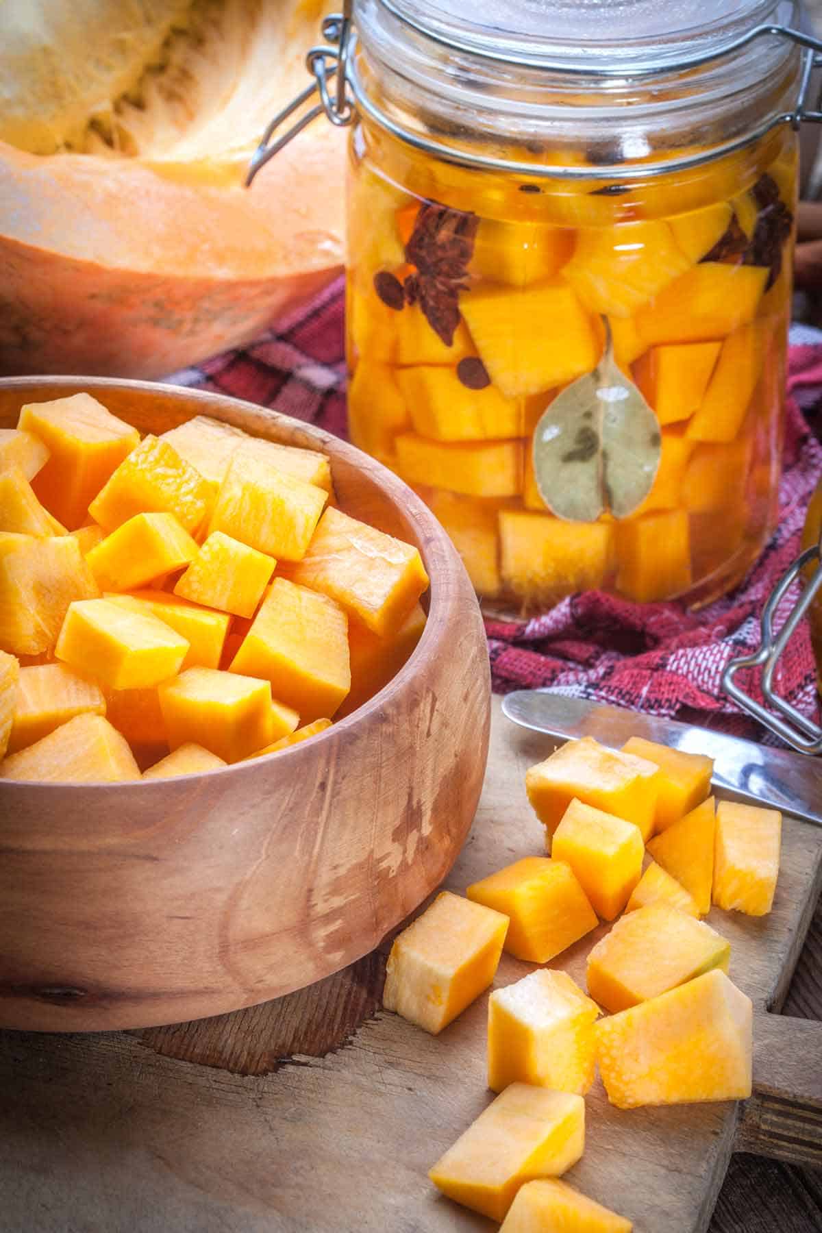 Bowl of cubed pumpkin and jar of pickled cubed pumpkin.