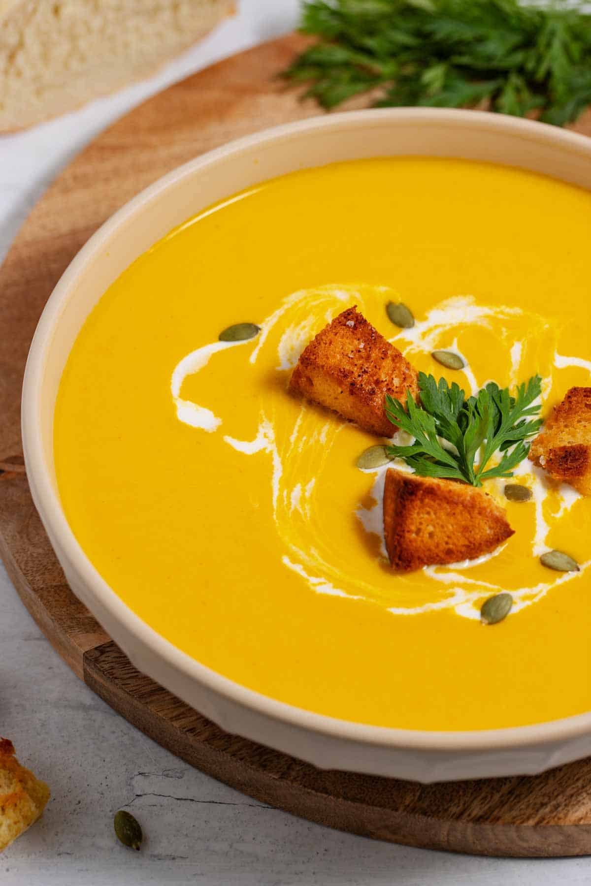 Bowl of spicy butternut squash soup with cream cheese, garnished with croutons.