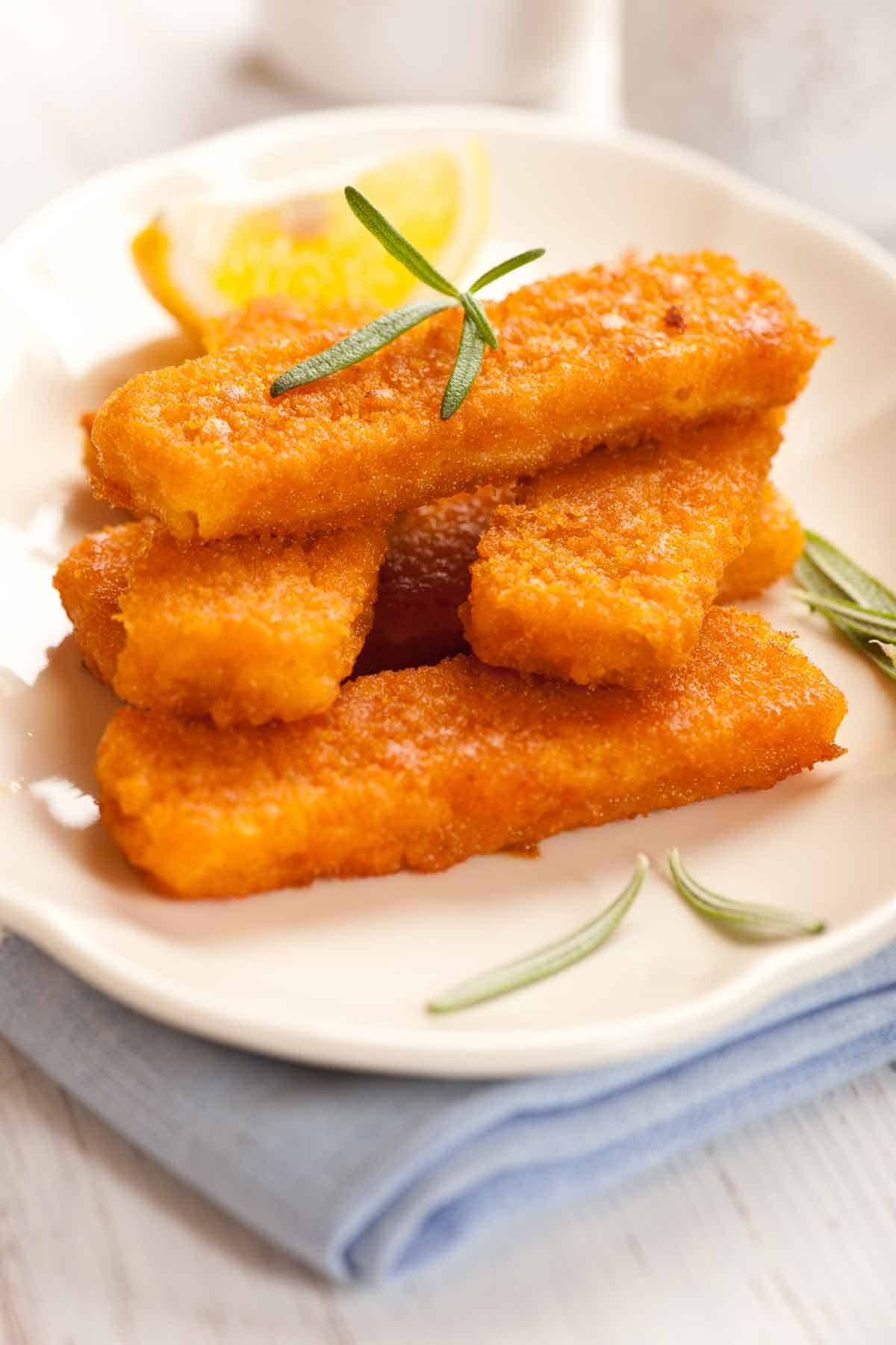 Plate of stacked fish sticks.