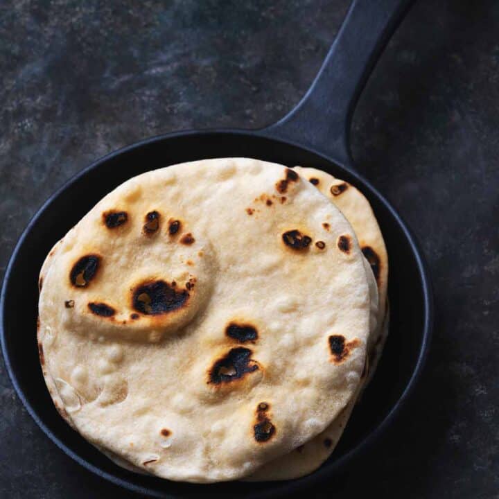 A stack of flatbread in a dark skillet.