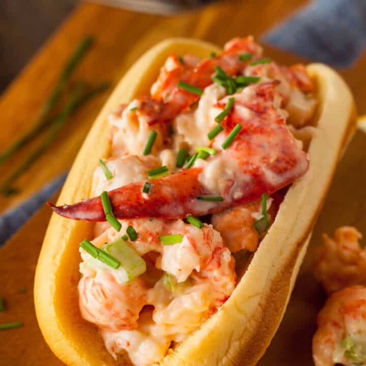 Lobster roll on a toasted hotdog bun, garnished with chives.