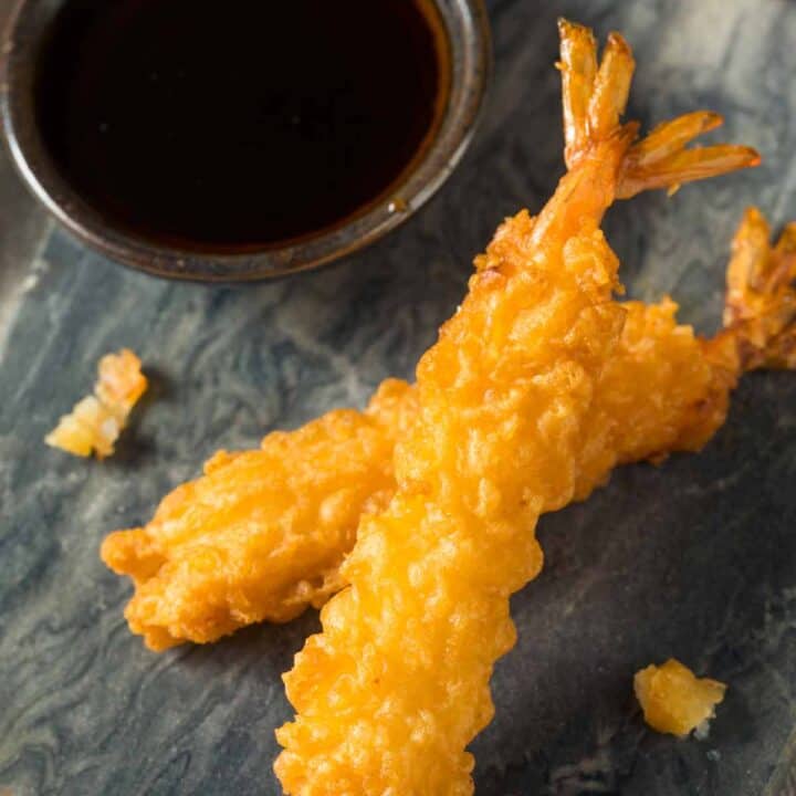 Plate of tempura shrimp with a small bowl of soy sauce.