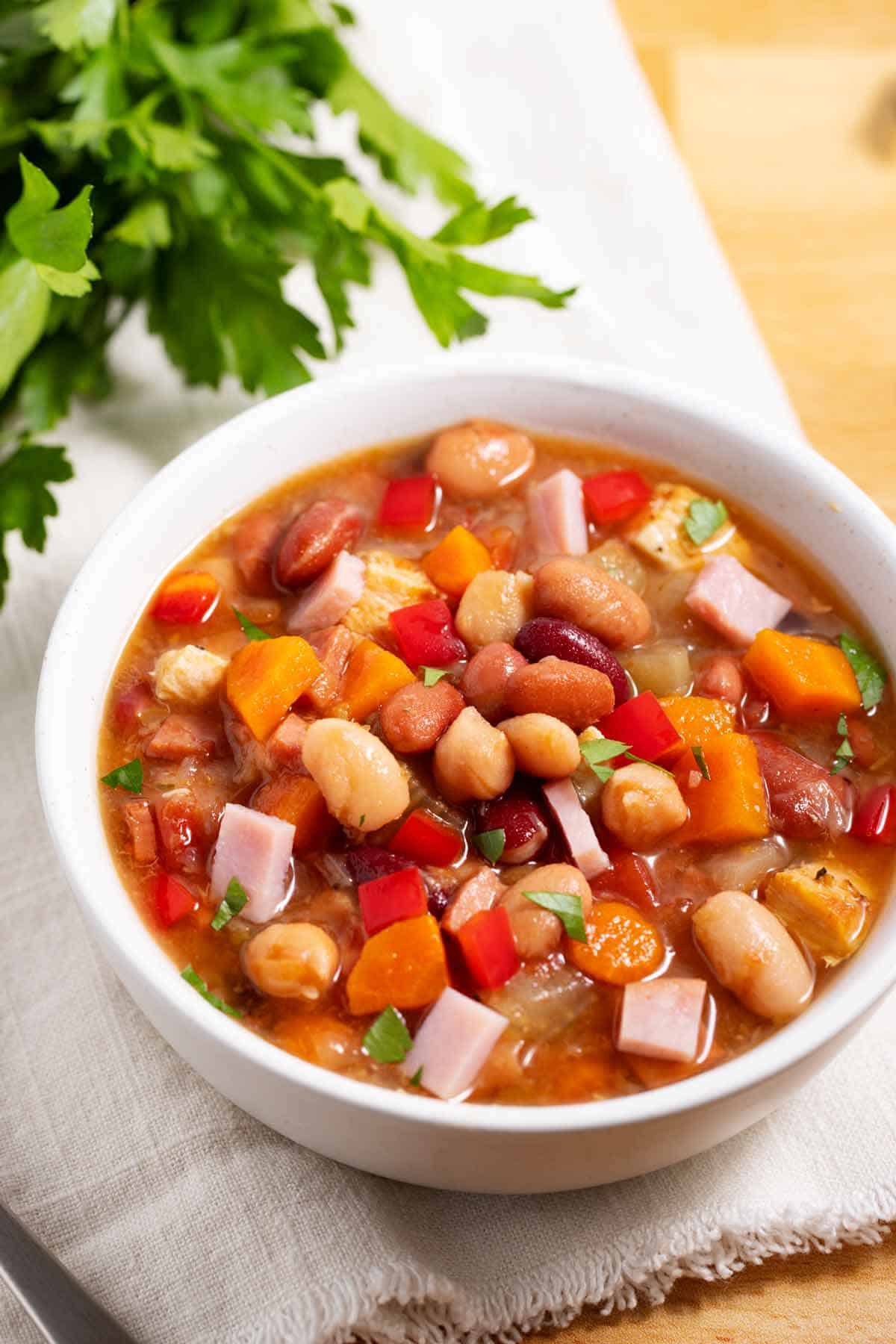 Bowl of 15-bean soup with greens in the background.