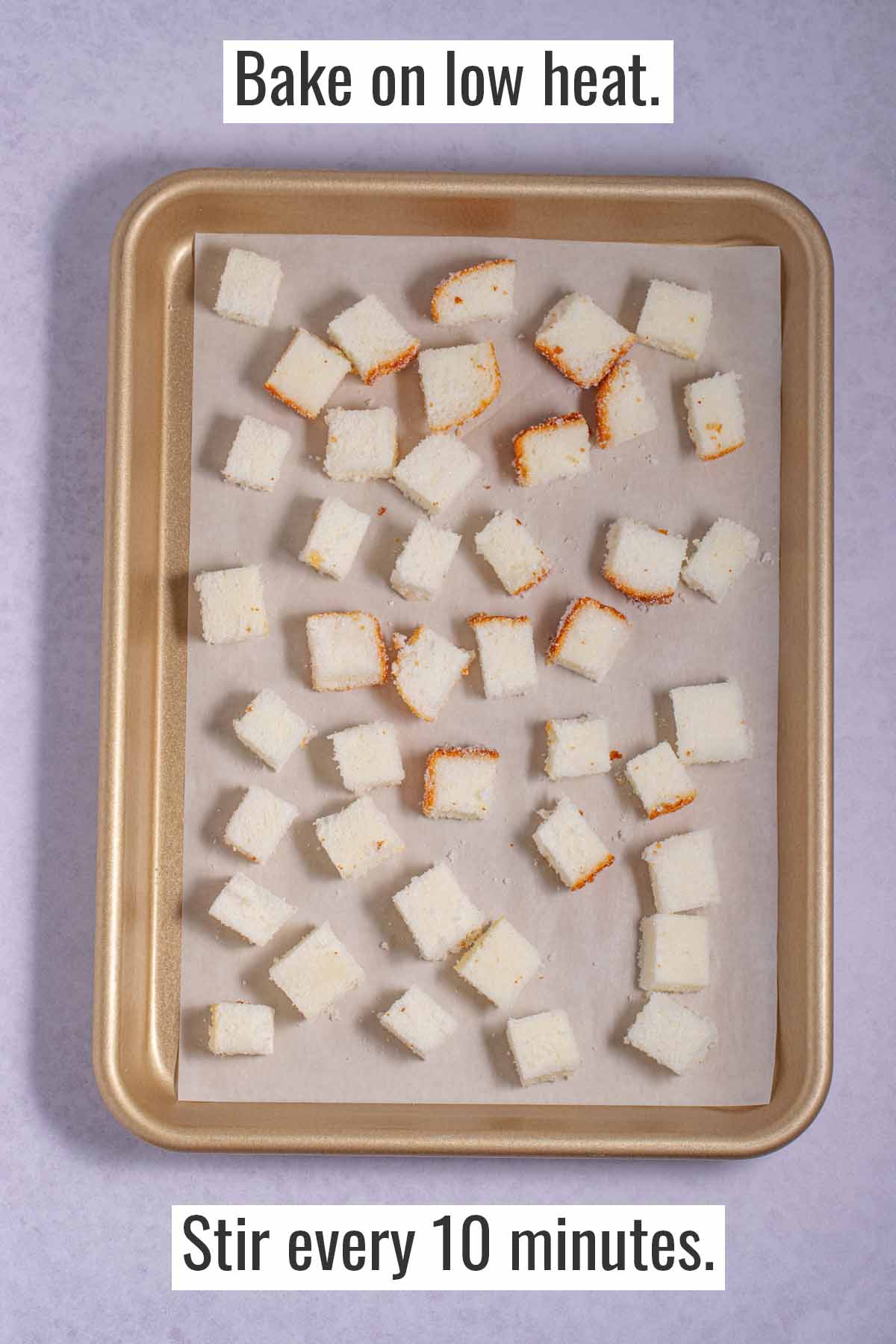 Sheet pan with angel food cake cubes mixed with melted butter and sugar. The pan is ready to go in the oven to bake the cake cubes into croutons.