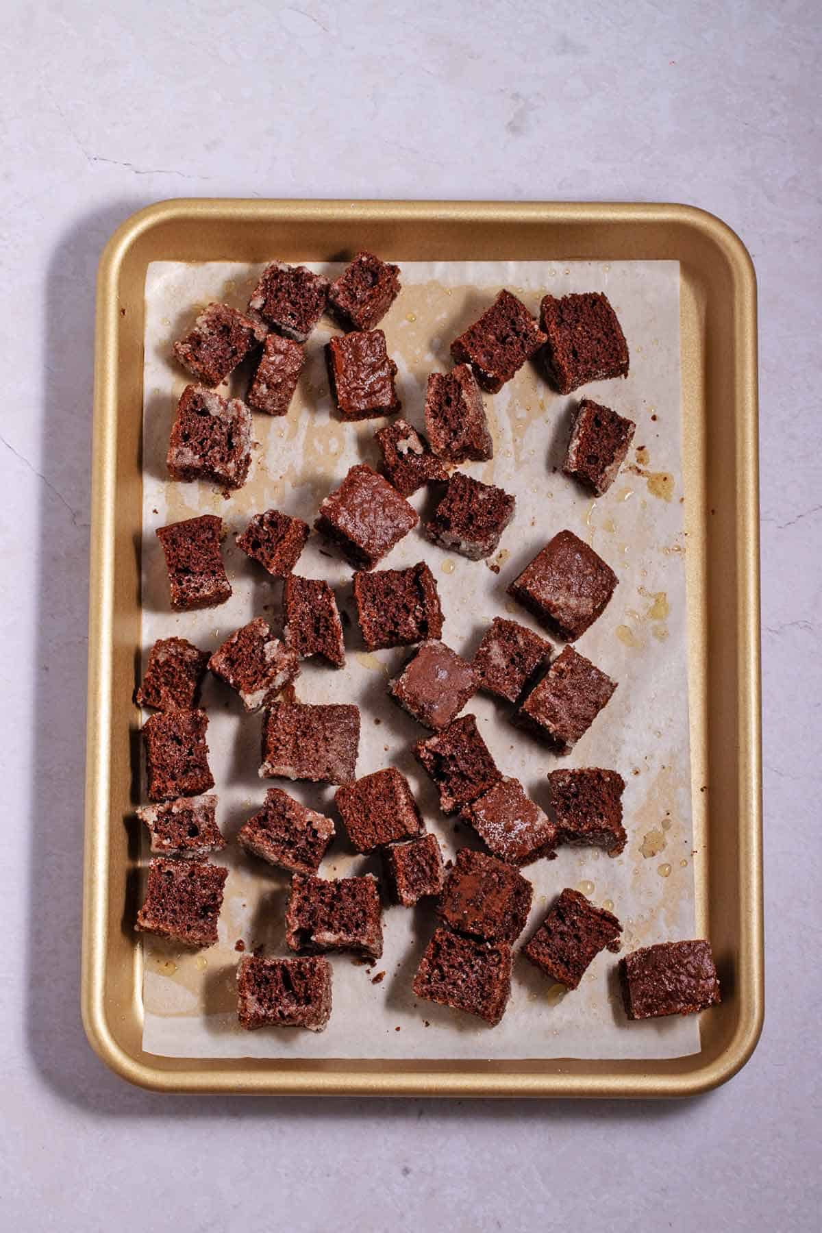 Sheet pan with baked chocolate cake croutons.