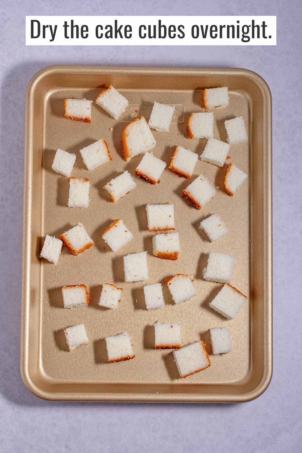Sheet pan with angel food cake cubes sitting on the counter to dry out.