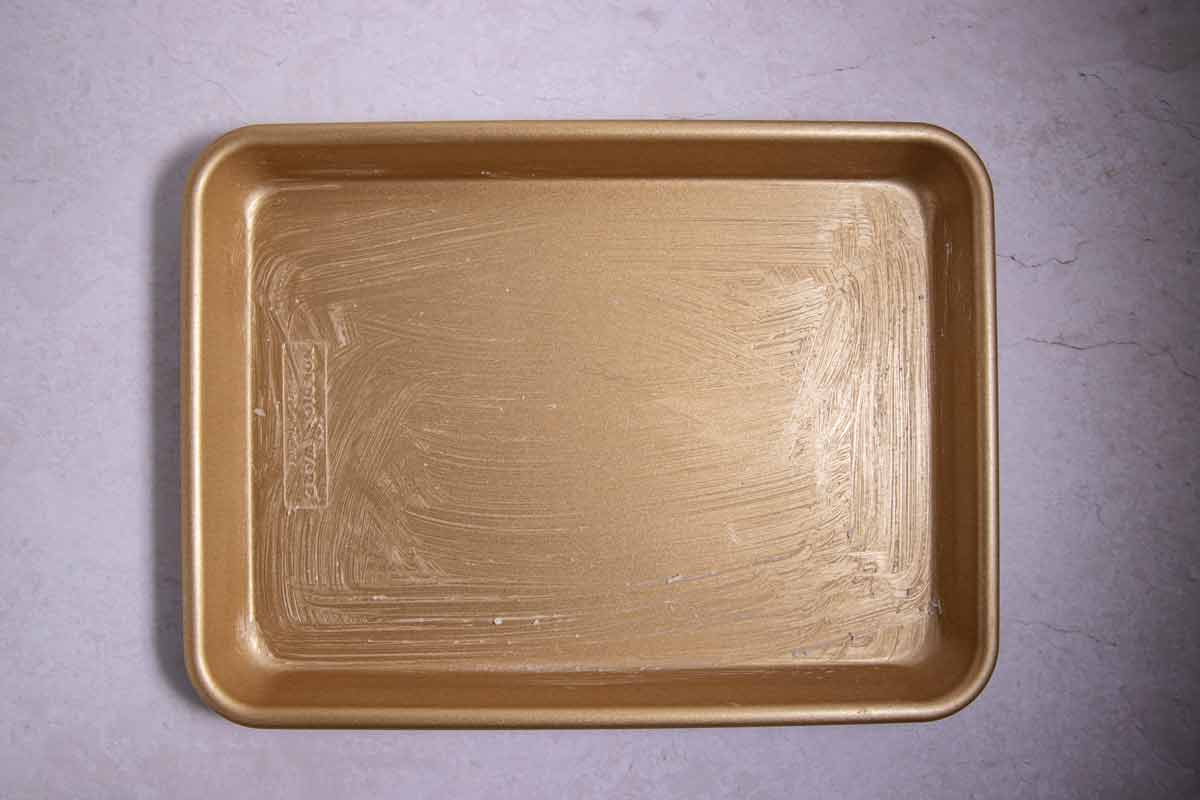 Greased quarter sheet pan for birthday cake Rice Krispies treats.