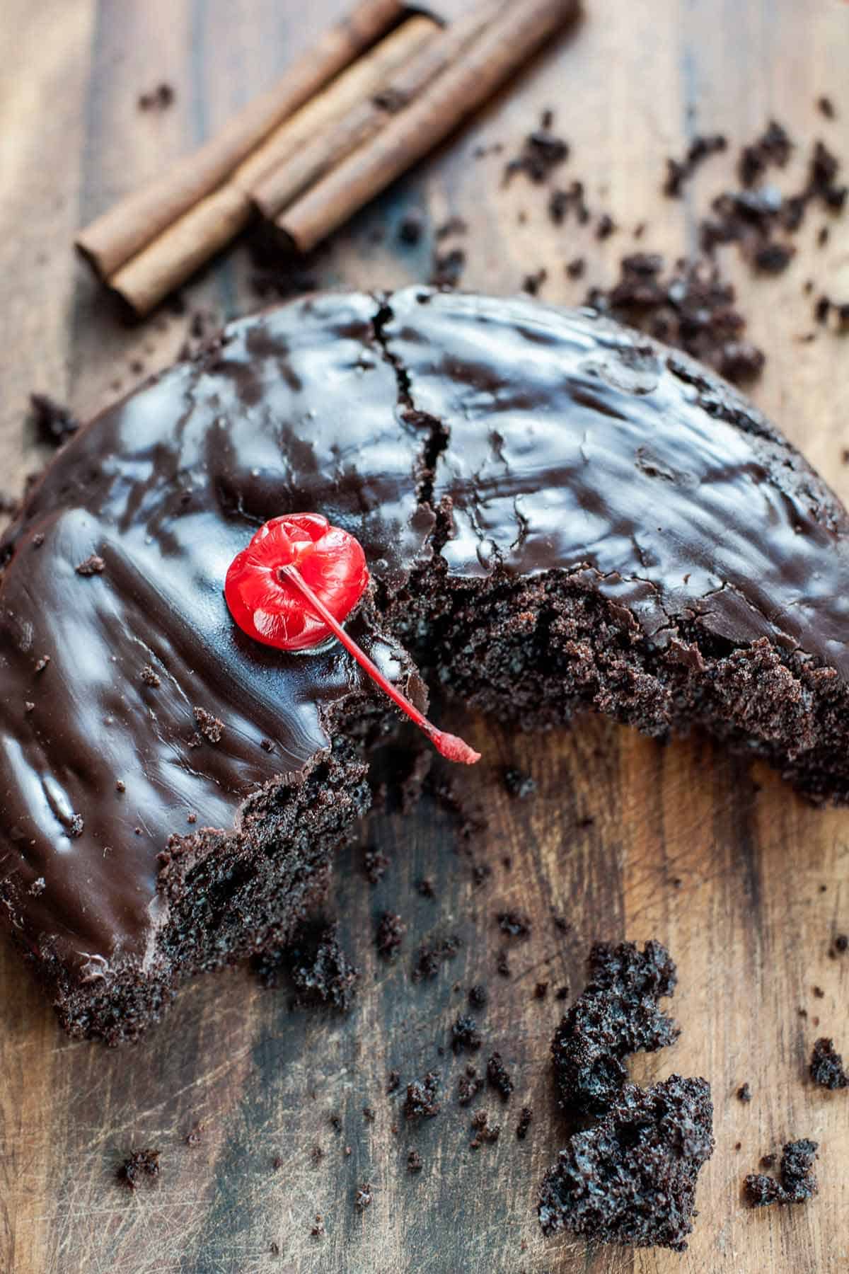 Half of a leftover chocolate cake with a cherry on top.