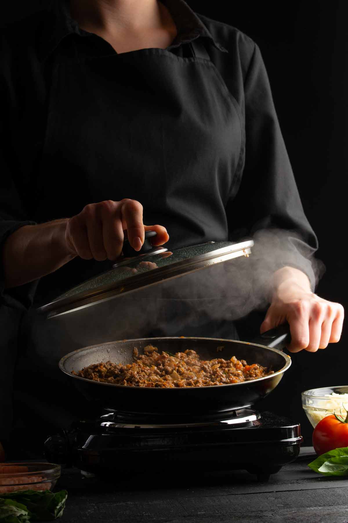 Woman reheating leftover sloppy joes in a skillet.