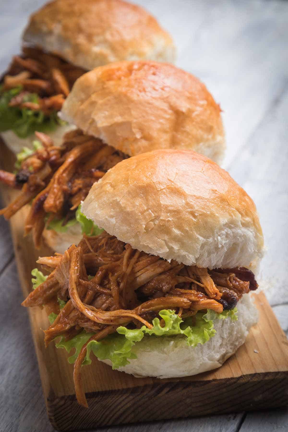 Pulled pork sliders on a bread board.