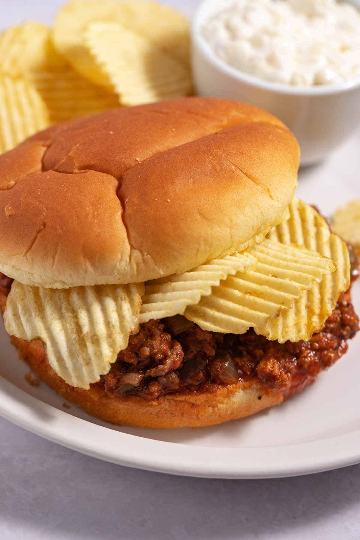 Sloppy joes on a bun with potato chips as a topping.
