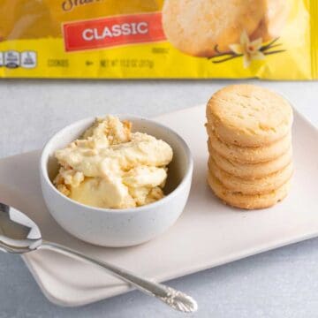 A bowl of banana pudding made with shortbread cookies with a stack of cookies next to it.