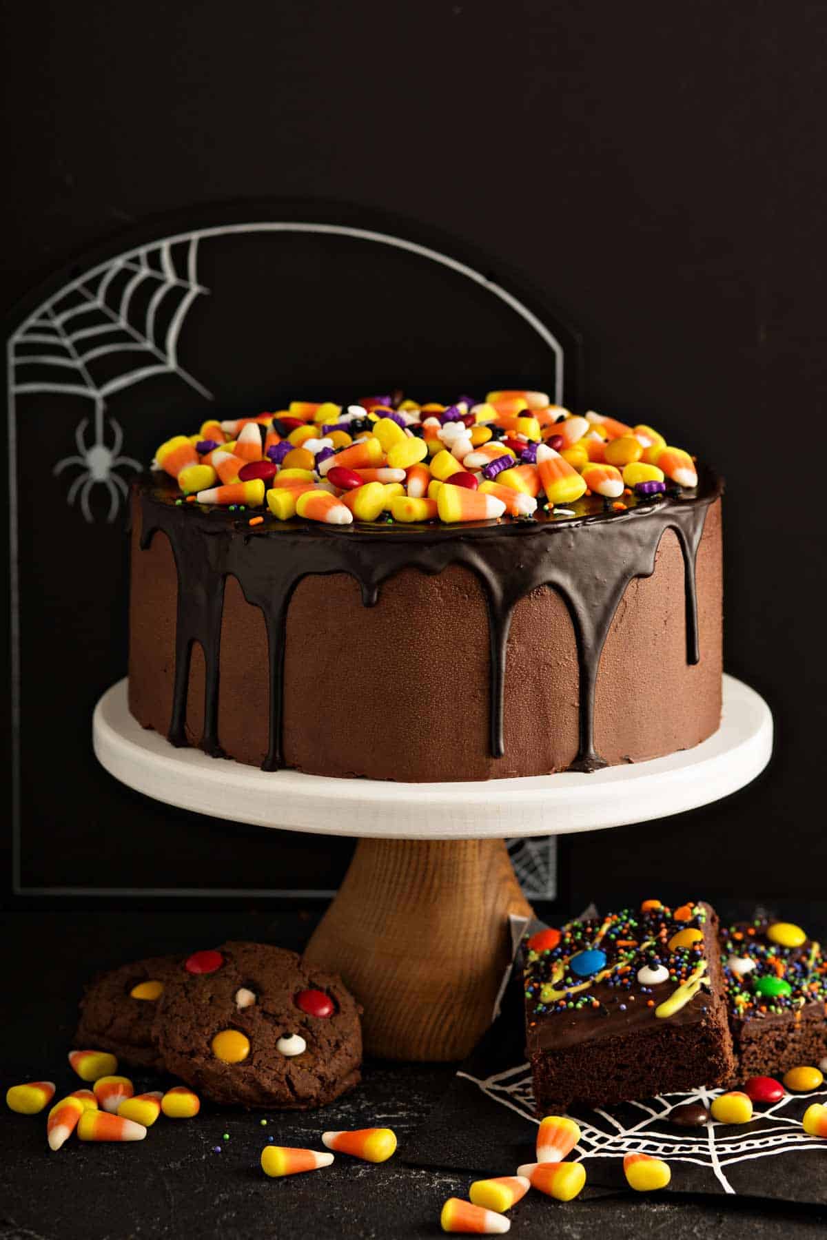 Chocolate Halloween cake decorated with candy corn and M&Ms with minimalist design.