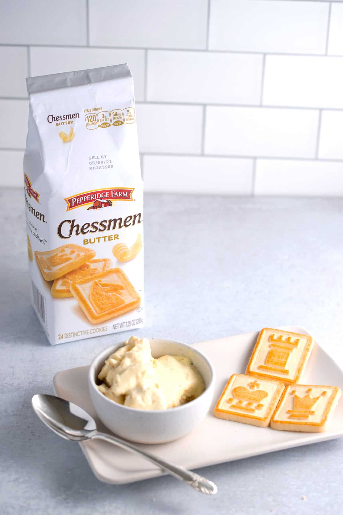 A bowl of banana pudding made with butter cookies with a package of Chessmen butter cookies in the background.