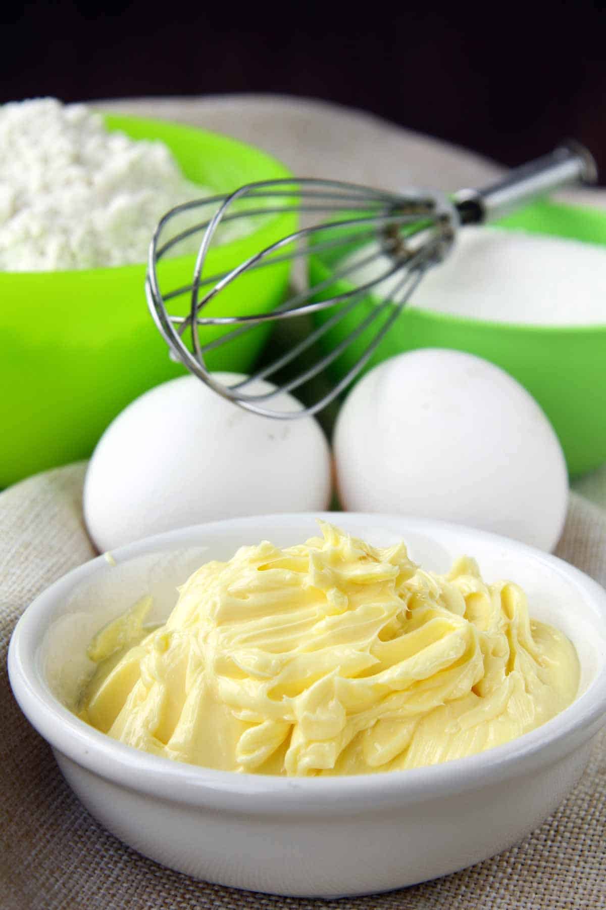 Cookie ingredients -- butter, eggs, flour, sugar, and wire whisk.