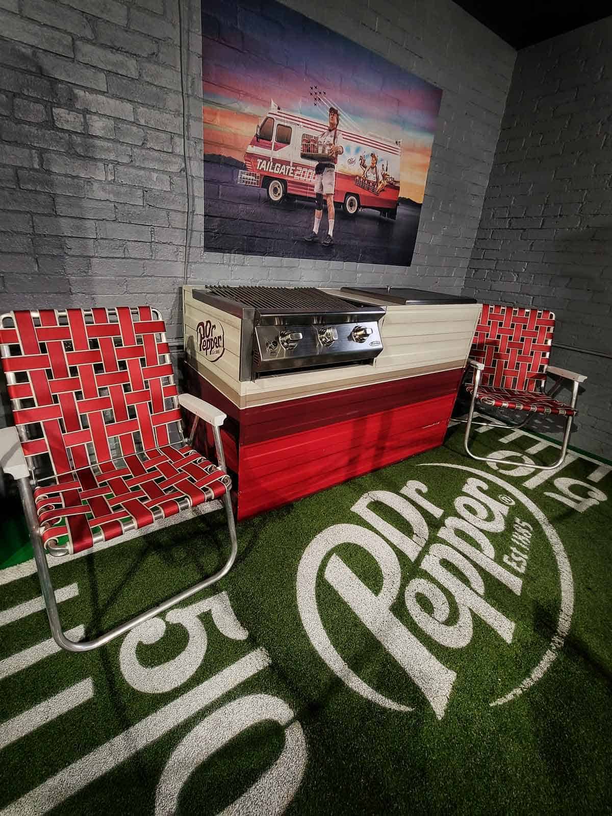 One of the displays at Dr. Pepper World Museum showing vintage poster, lawn chairs, and outside grill.