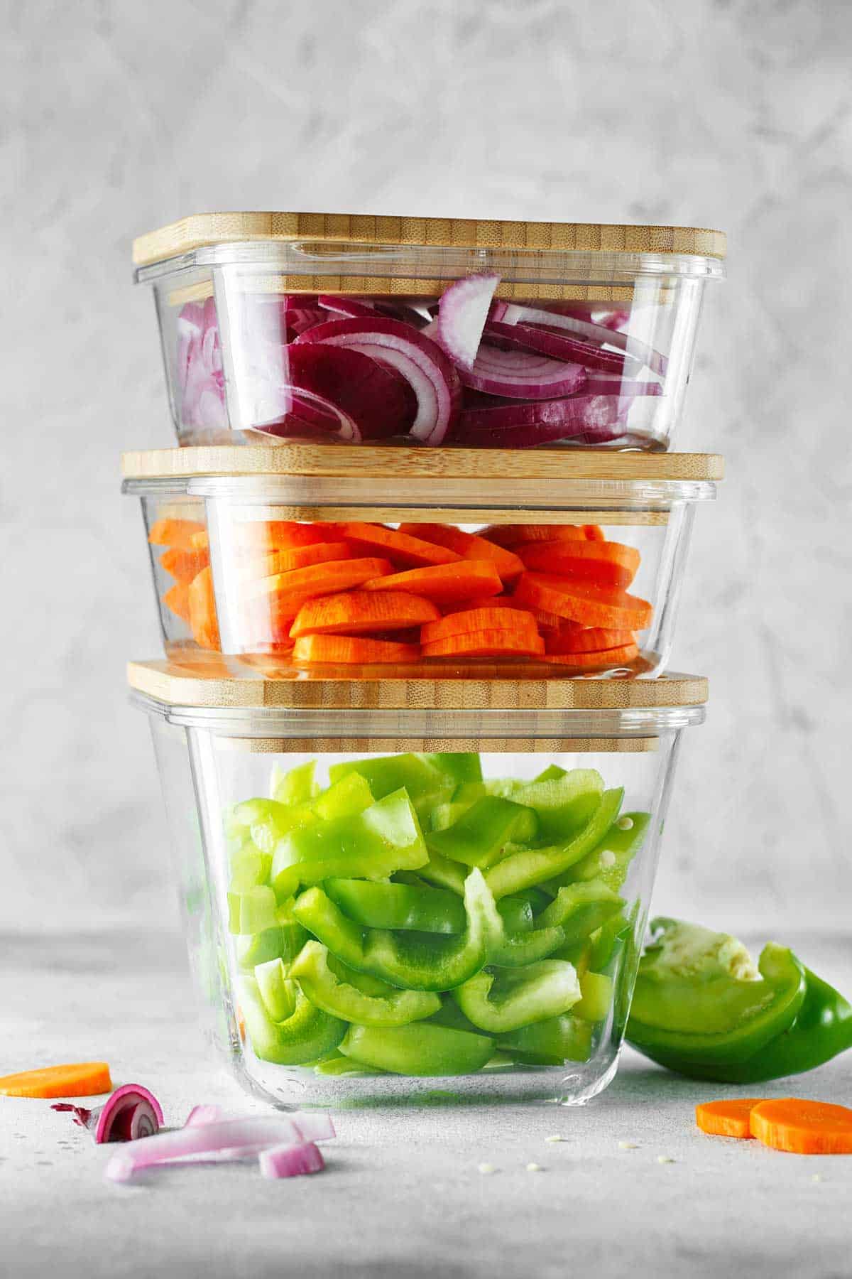 Stack of clear storage containers with chopped veggies in them.