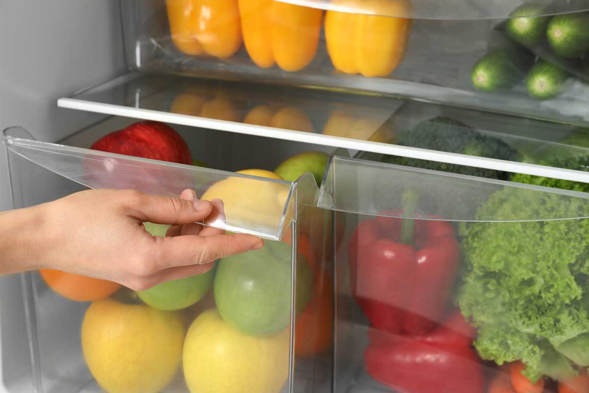 Close up of the crisper fruit and vegetable bins in an open refrigerator.