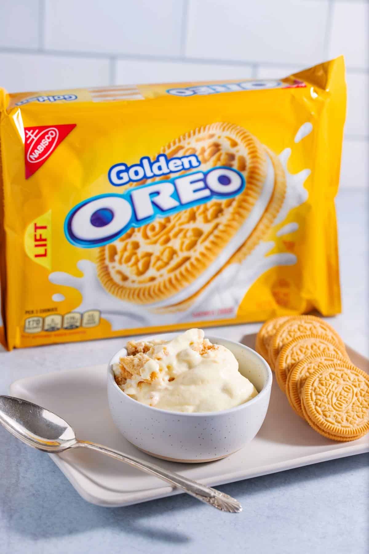 A bowl of banana pudding made with golden Oreos with a package of golden Oreos in the background.