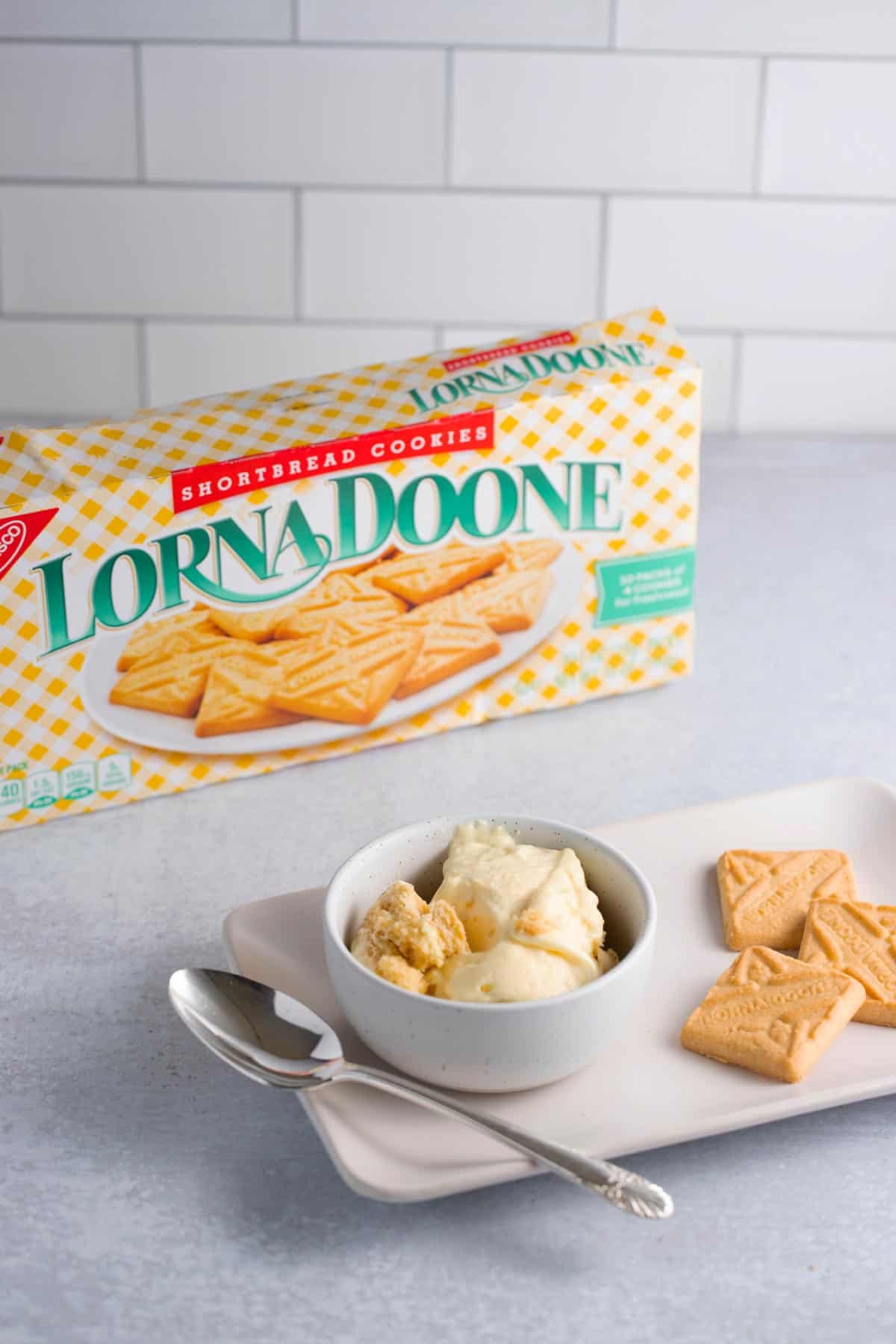 A bowl of banana pudding made with shortbread cookies with a box of Lorna Doone cookies in the background.