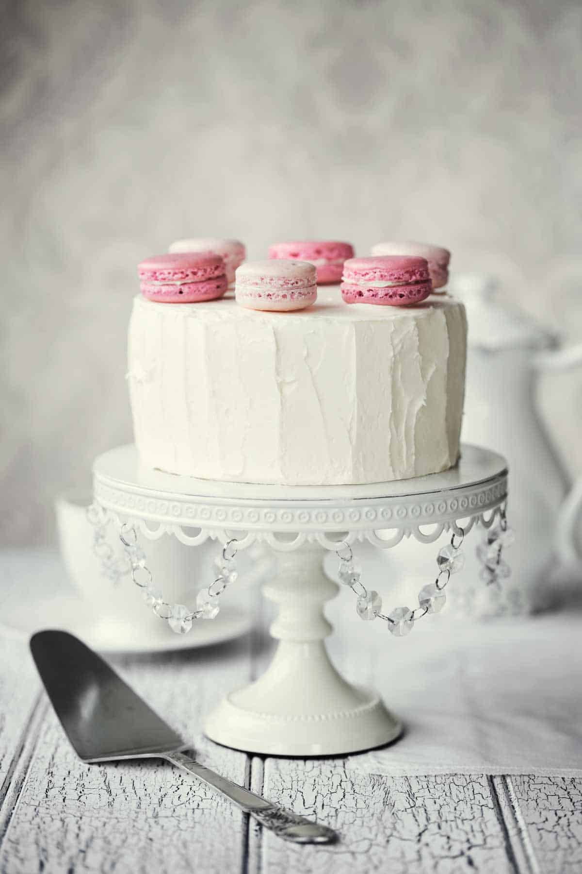 Minimalist white cake with macaroons on top.