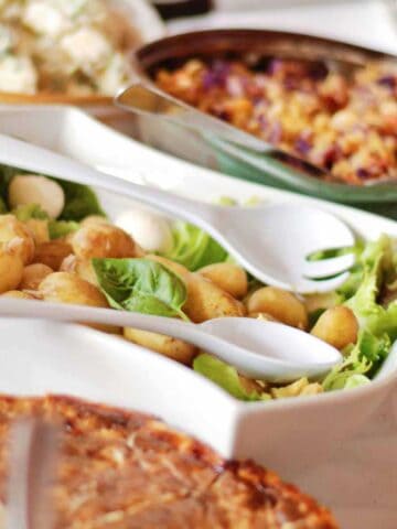 Dishes of sides that pair with chicken salad sitting on a luncheon table.