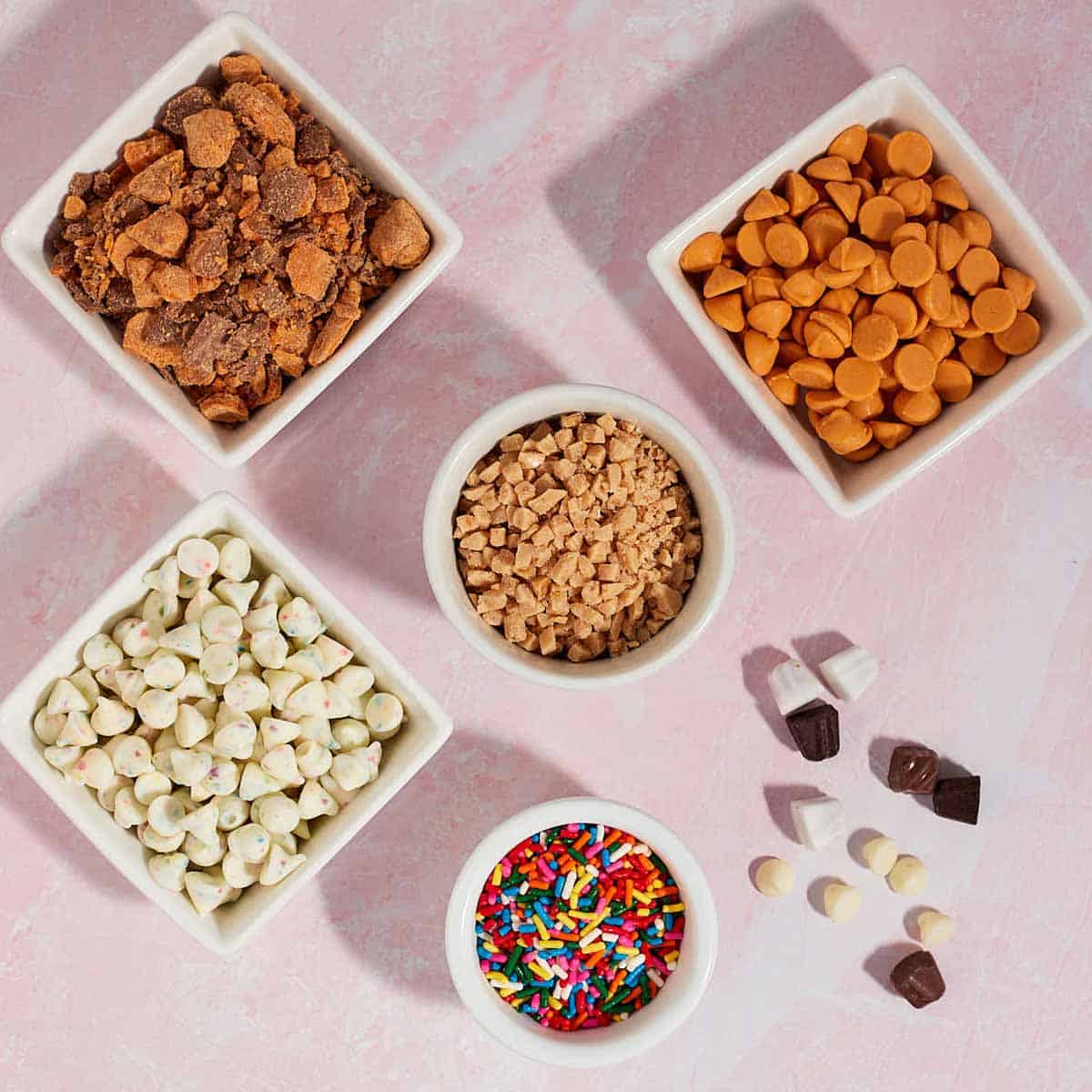 Bowls of baking chips (Funfetti, Heath, butterscotch, and toffee chips) to use as substitutes for chocolate chips in cookies.