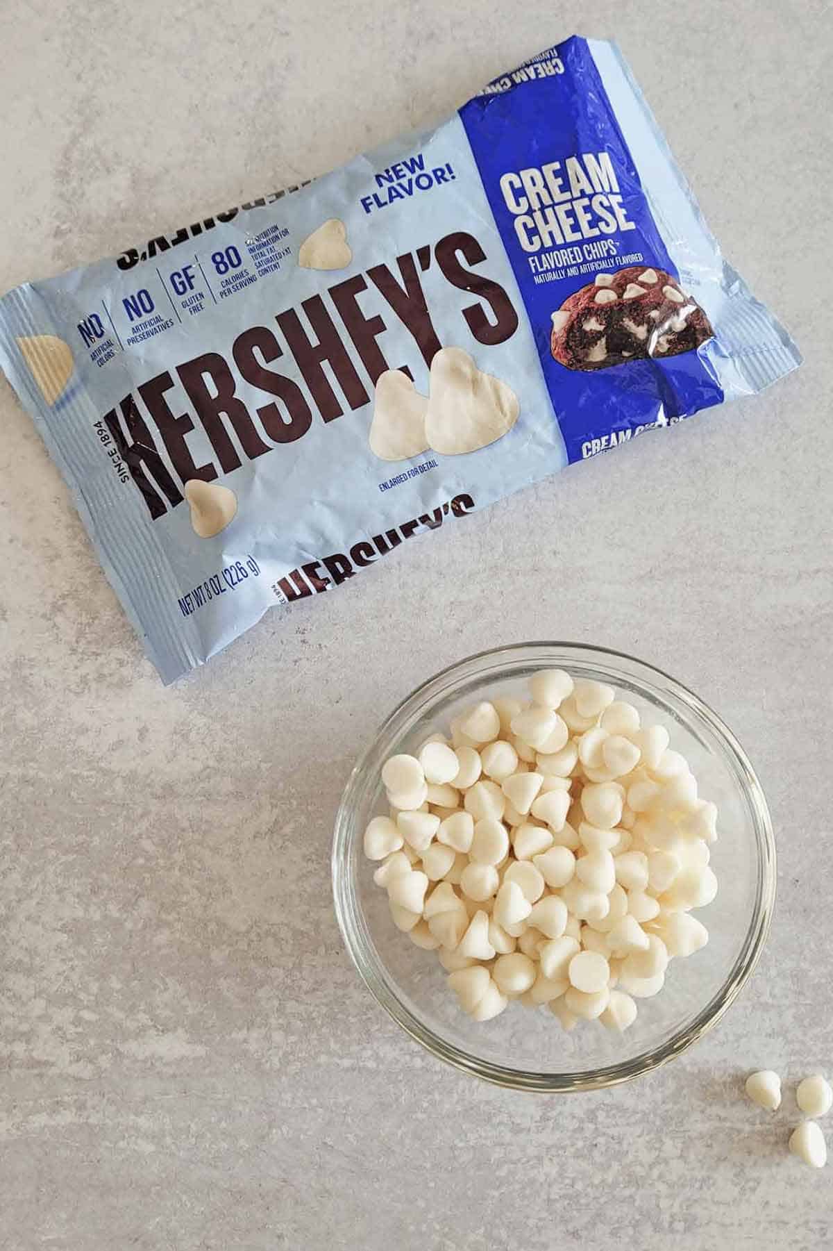 Package of Hershey's cream cheese flavored chips with a bowl of the pieces in front.