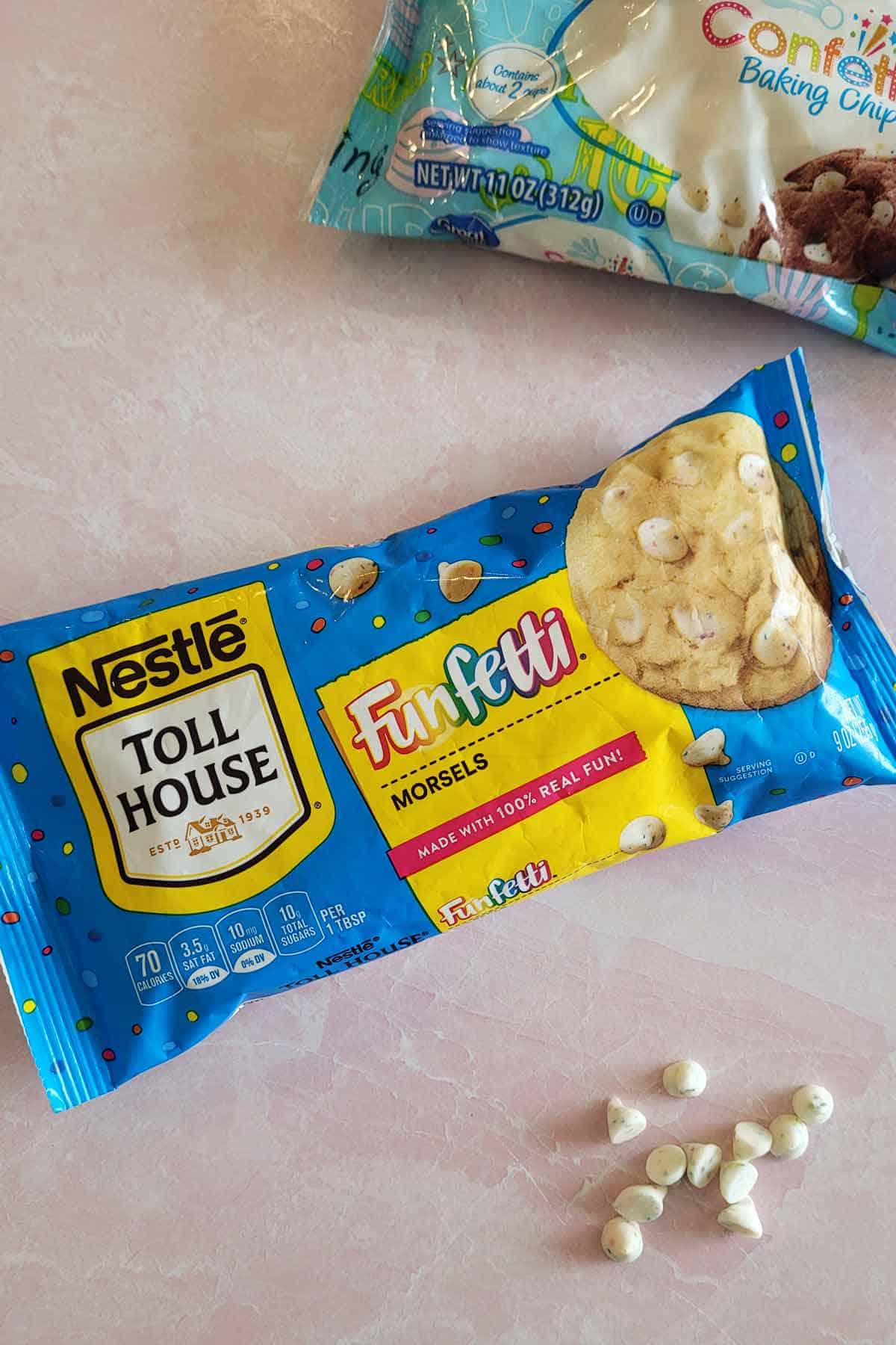 A bag of Nestle Toll House funfetti morsels and a bag of Great Value confetti baking chips.