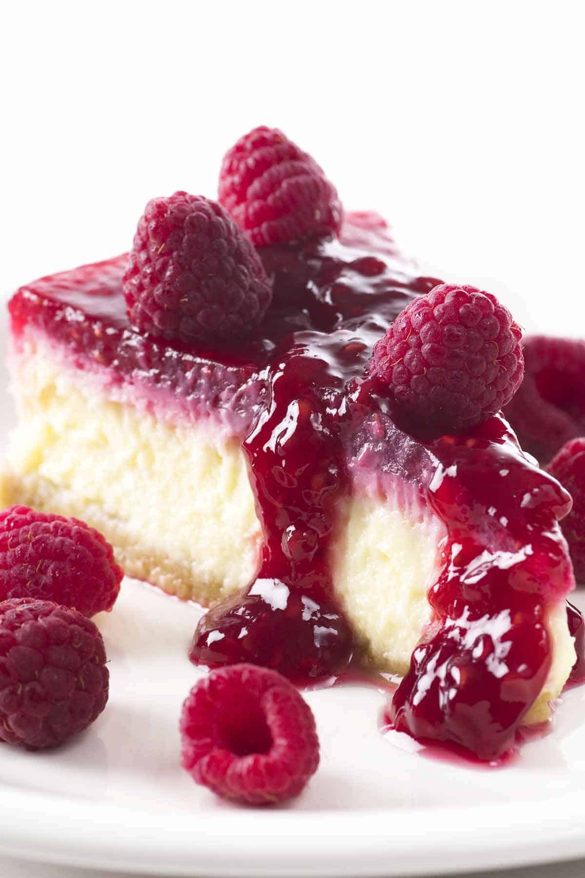 Slice of white chocolate cheesecake with raspberries.