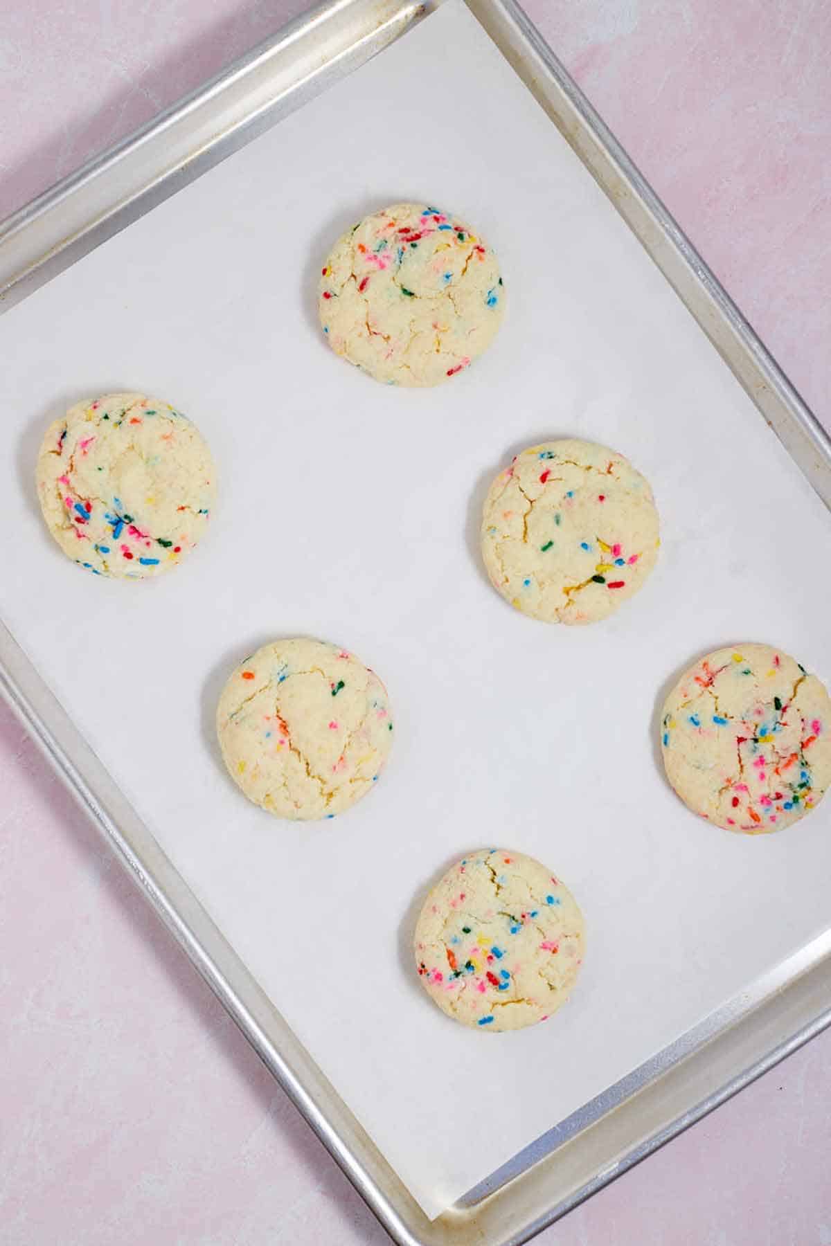 Baked Funfetti cookies on a cookie sheet.