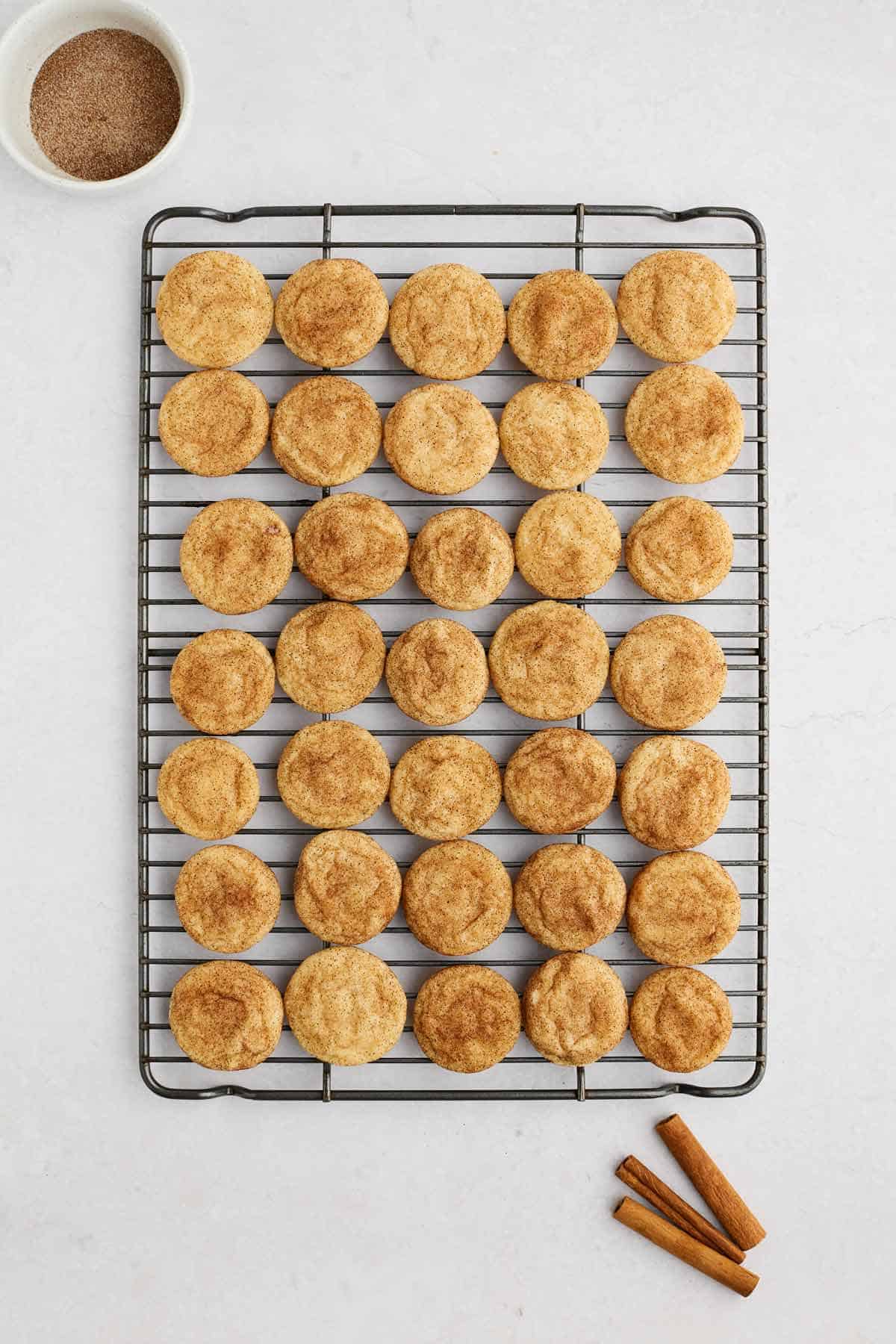Baked snickerdoodle cookies on a cooling rack.