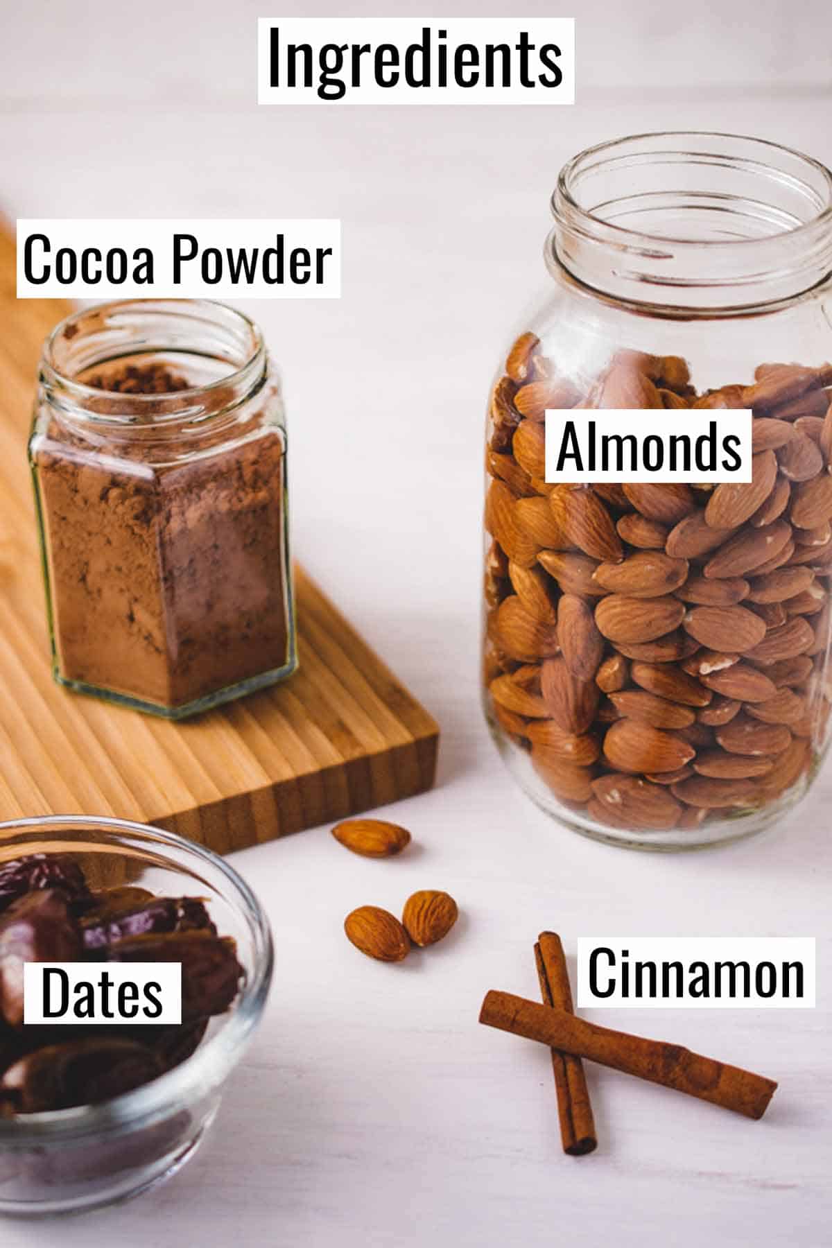 Ingredients for chocolate almond milk, including cocoa powder, almonds, cinnamon sticks, and dates.