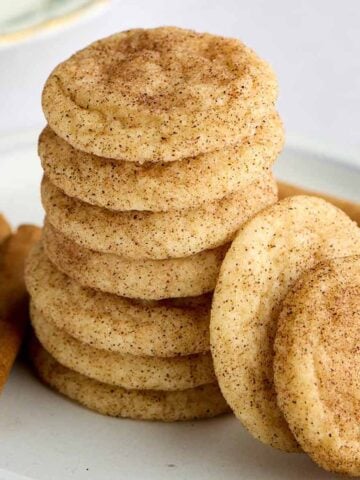 Stack of mini snickerdoodle cookies with two leaned against the stack.