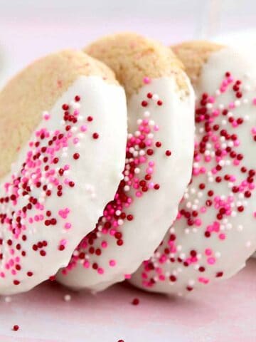 Three cherry chip cake mix cookies with sprinkles leaning against each other.