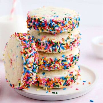 Stack of four Funfetti cookie sandwiches with one leaning against the stack.