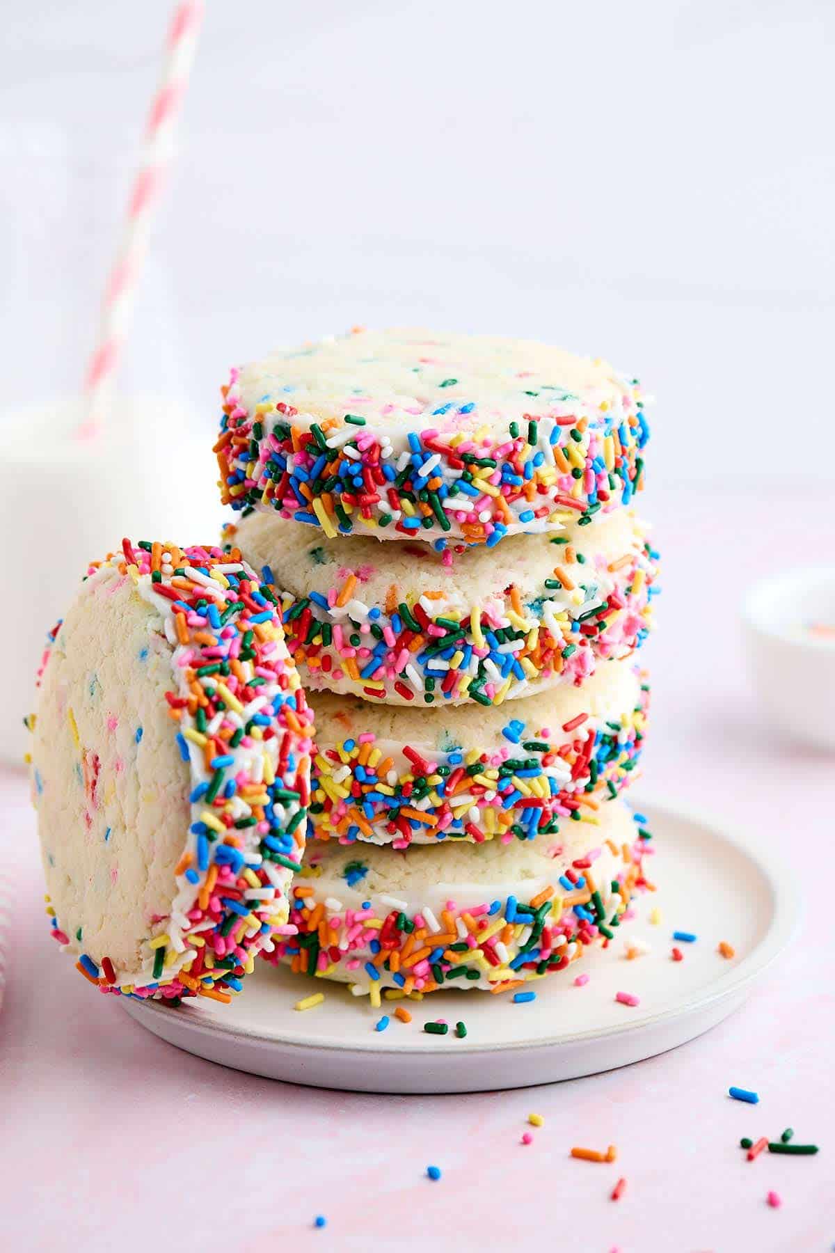 Tall stack of Funfetti cake mix cookie sandwiches with one leaning against the stack.