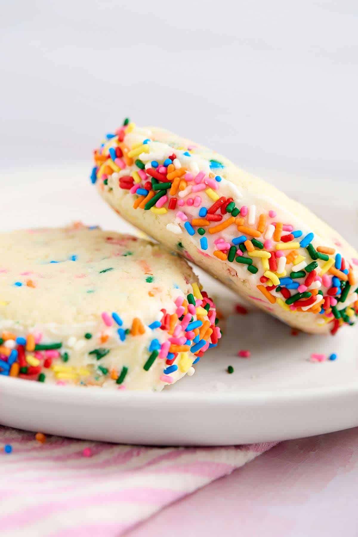 Two Funfetti cake mix cookie sandwiches on a dessert plate.