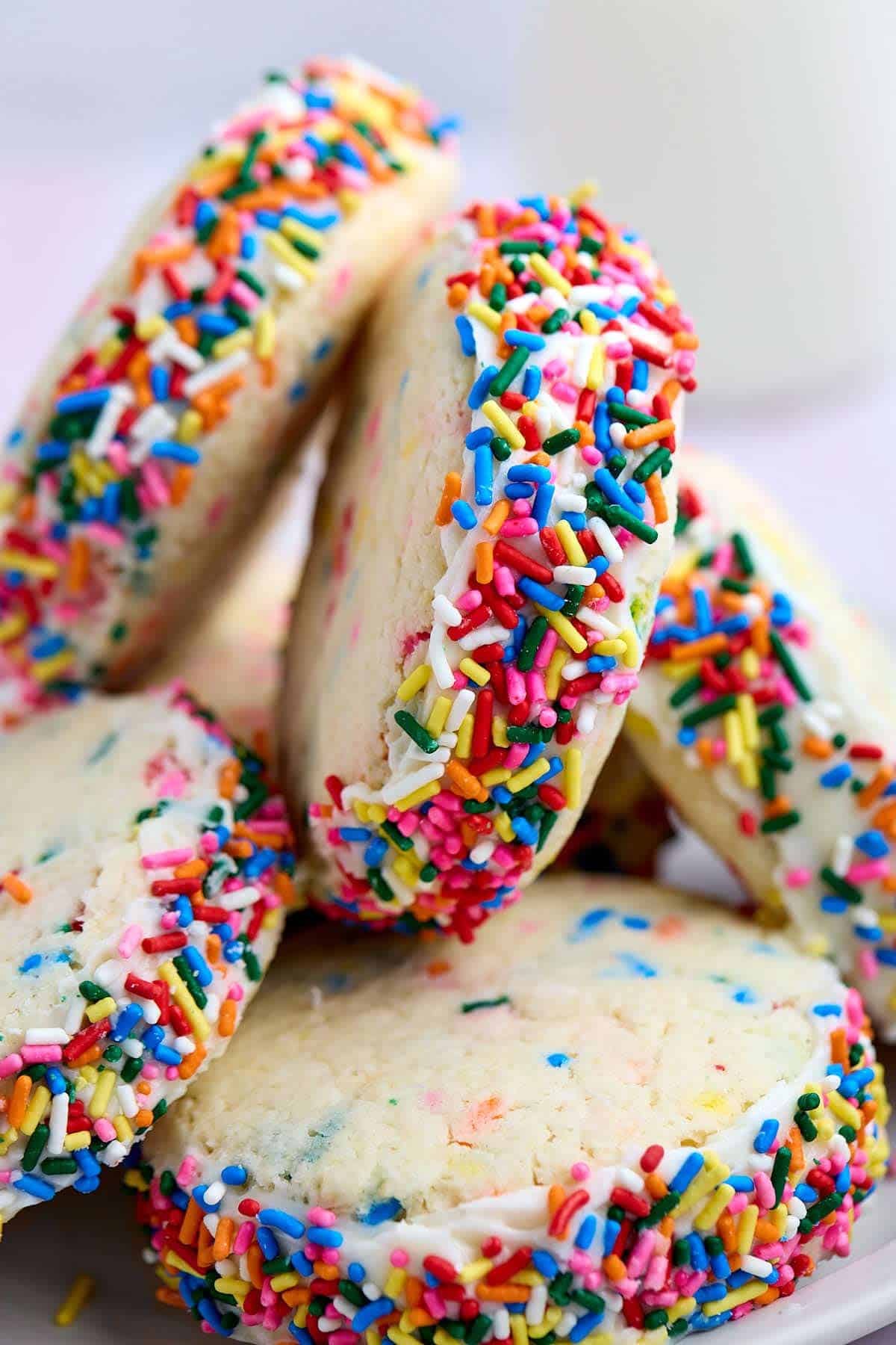 Funfetti cake mix cookie sandwiches stacked haphazardly on a plate.