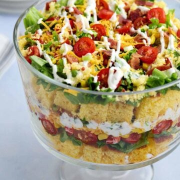 Glass bowl filled with layered cornbread salad without beans made with Jiffy mix.
