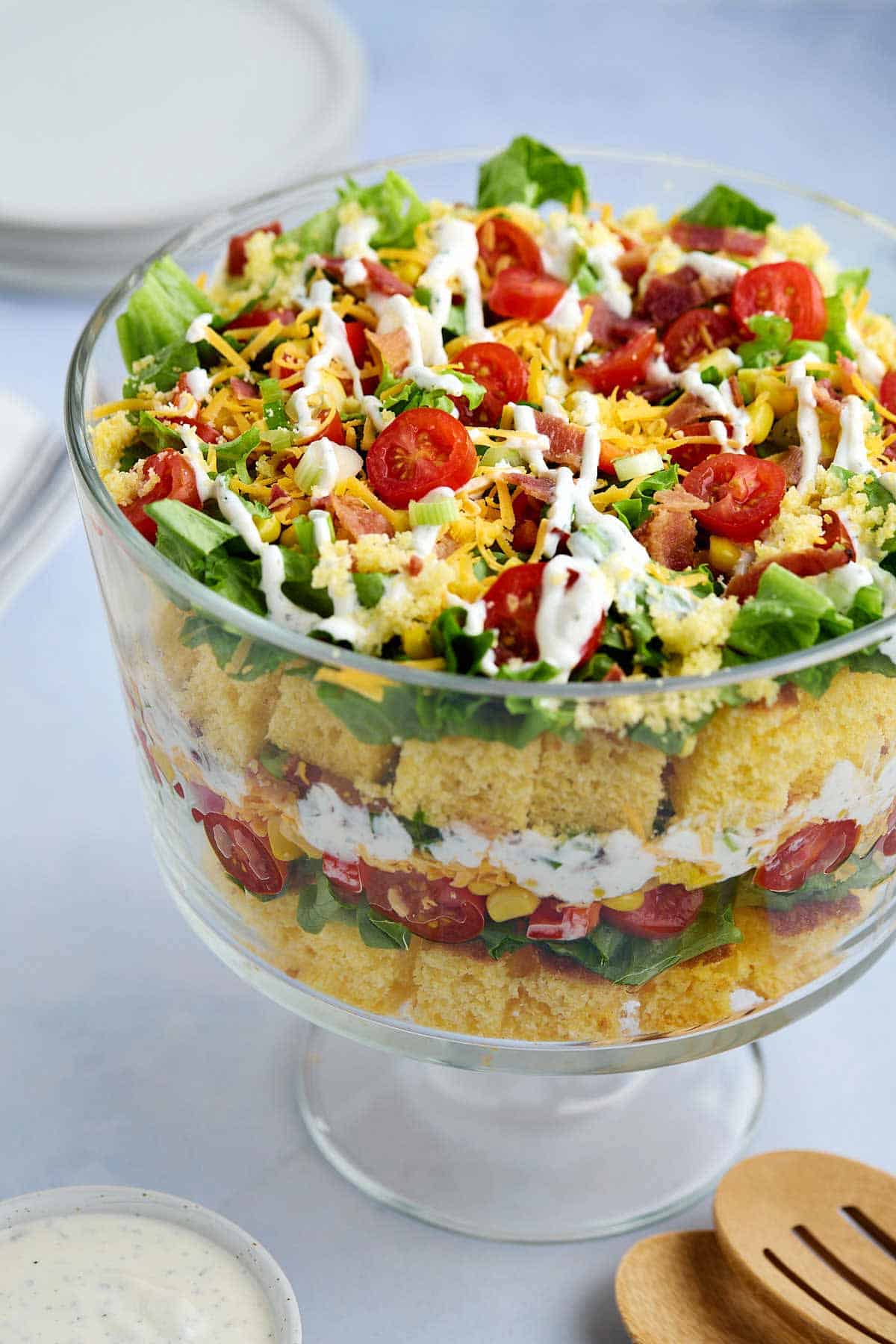 Glass bowl filled with layered cornbread salad without beans made with Jiffy mix.