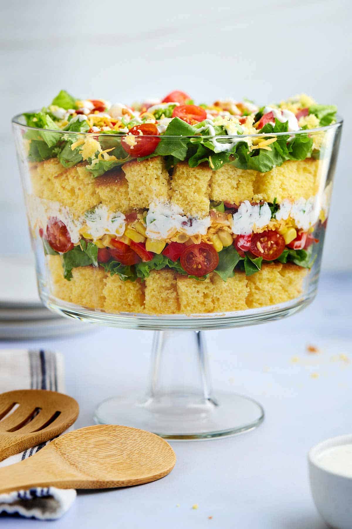 Layered cornbread salad without beans in a glass serving dish.