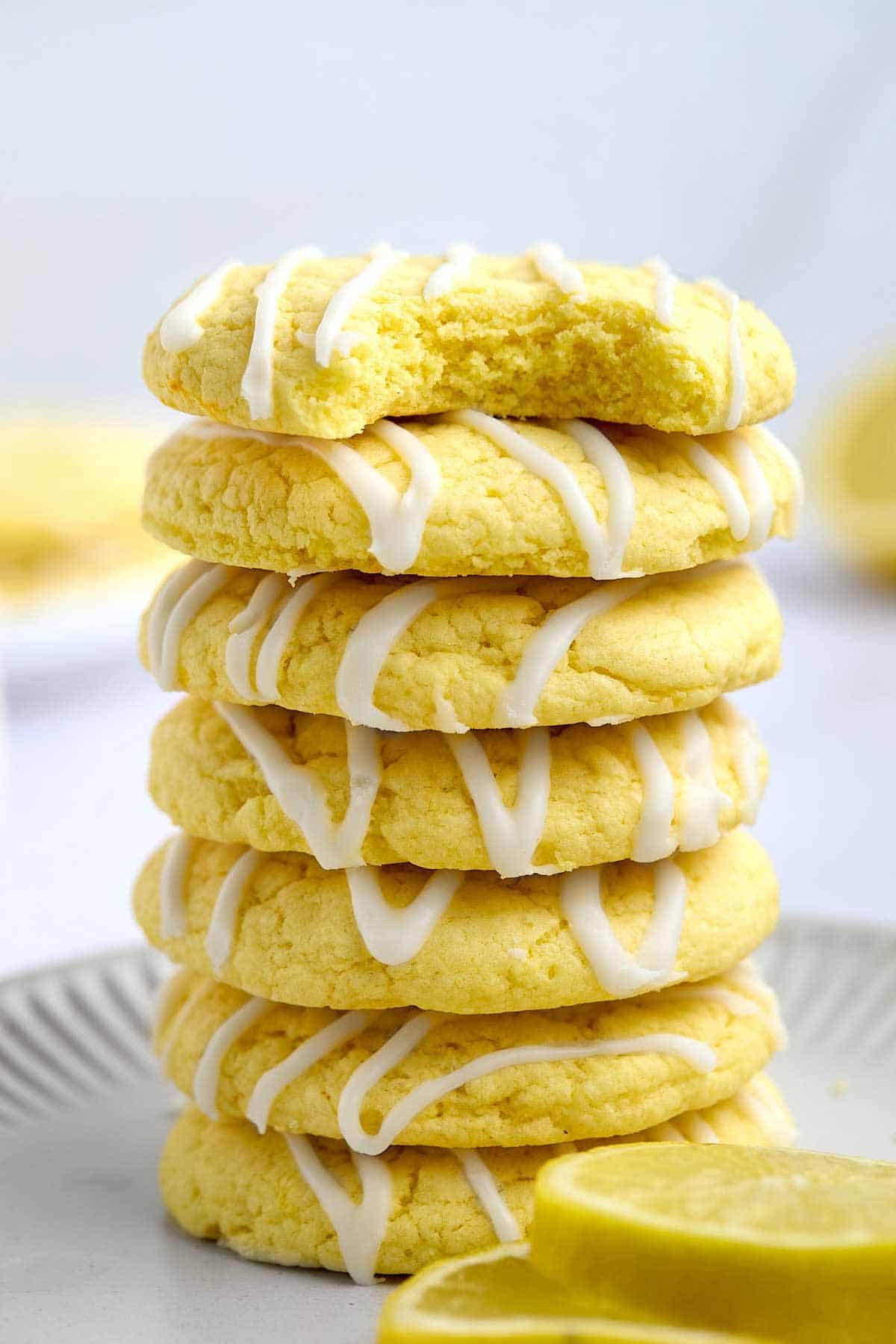 Tall stack of lemon cake mix cookies with a bite taken out of the top cookie.