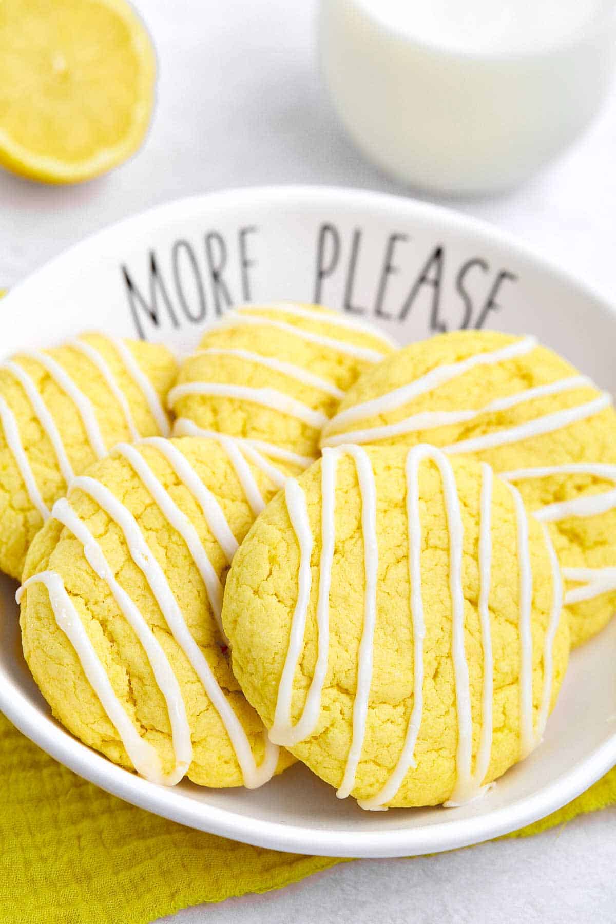 Bowl of lemon cake mix cookies drizzled with lemon white chocolate.