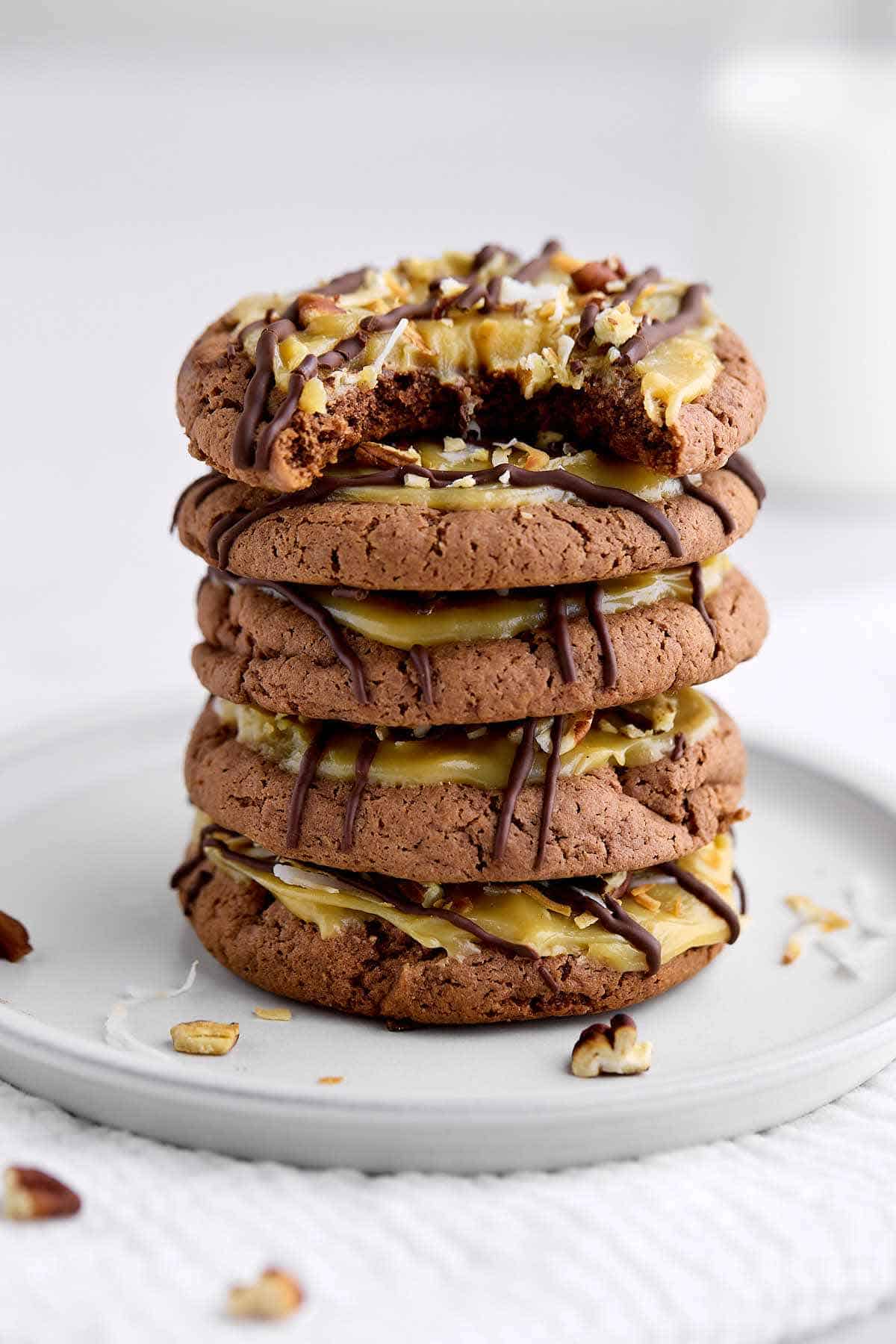 Stack of German chocolate cookies with a bite taken out of the top cookie.