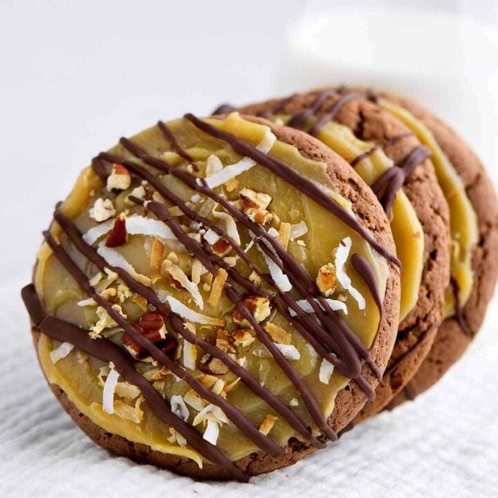 German chocolate cake mix cookies with coconut pecan frosting upright leaning against each other.