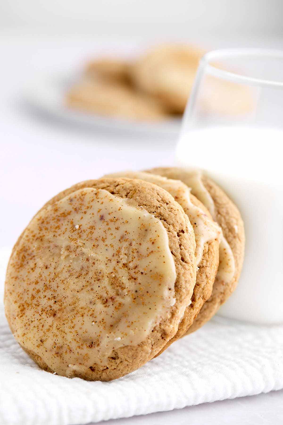 Spice cake mix cookies leaning against a glass of milk.