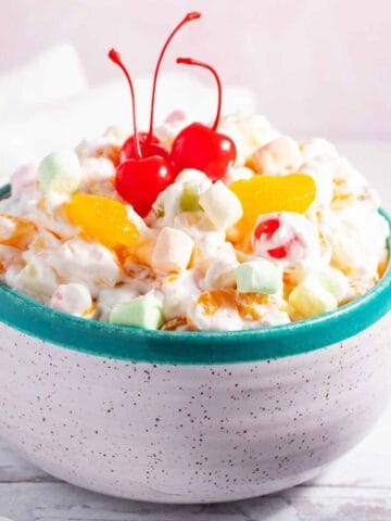 Closeup of bowl of ambrosia salad with Cool Whip and marshmallows.